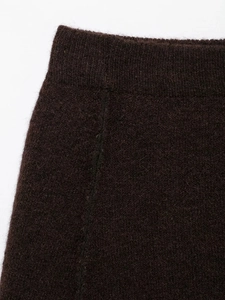 Close-up of dark brown knit plush fabric showing fine texture and sewing detail