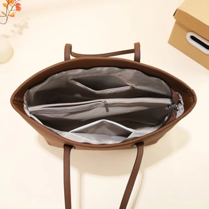 Detailed view of brown lychee leather tote bag interior with multiple compartments