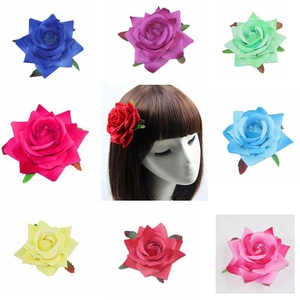 Detail showcasing nine colors of silk rose hair clips worn on a brunette model