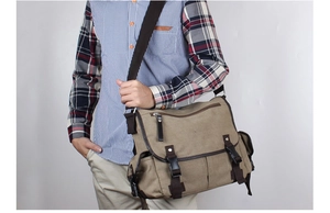 Detail of vintage khaki canvas messenger bag with leather trim and adjustable strap