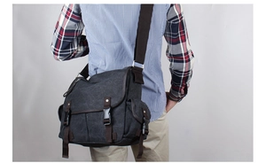 Detail of large canvas messenger bag with double buckles and adjustable strap in charcoal grey