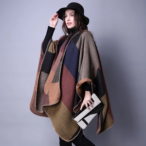 Detail of geometric color-block pattern and blanket-stitched edges on a thick knit poncho