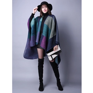 Detail shot of a color block knit poncho wrap with navy, green, and purple geometric panels