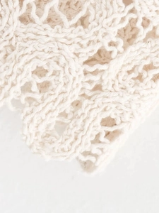 Macro detail of off-white open-knit crochet fabric showing soft honeycomb texture