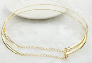 Detail of a bold gold punk choker necklace with curved metal bars and chains