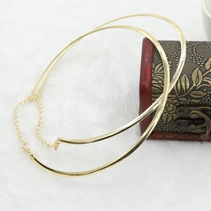 Macro detail of high-shine gold metal collar necklace with adjustable lobster clasp