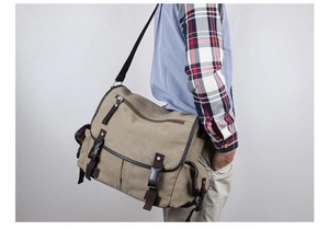 Detail view of khaki canvas messenger bag featuring large flap and quick-release buckles