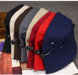 Close-up of colorful canvas bucket hats with metal eyelets and adjustable sport straps