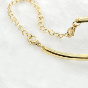 Detailed close-up of a punk style golden metallic collar necklace with lobster clasp