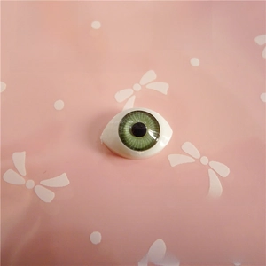 Close-up of a 12x16mm green acrylic doll eye with detailed iris texture for DIY crafts