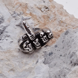 Macro detail of silver vintage stainless steel ring featuring a middle finger gesture design