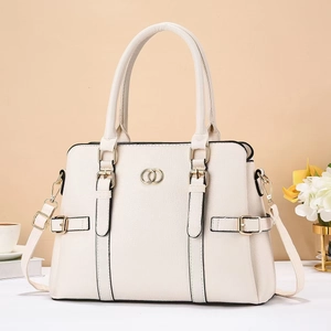 Elegant ivory lychee leather tote bag with gold rings and adjustable strap in lifestyle setting