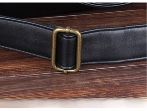 Detail of premium bronze hardware buckle and adjustable strap on black leather bag