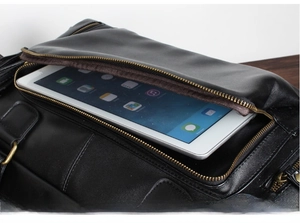 Detail view of large black PU leather messenger bag showing front pocket fitting an iPad