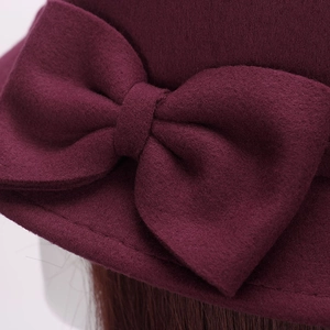 Elegant burgundy wool dome hat featuring a large layered bow and refined stitching