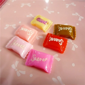 Macro view of colorful resin candy charms with Sweet text for DIY crafts accessories