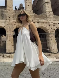 Detail of a white halter neck A-line dress worn by a model in front of the Colosseum