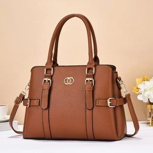 Detail of brown litchi pattern leather tote with golden hardware and adjustable strap