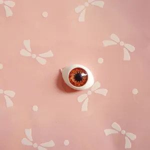 Macro detail of oval acrylic doll eye showing brown gradient iris and radial textures