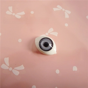 Close-up of a 12x16mm oval acrylic doll eye with grey iris and detailed radial texture