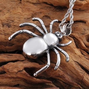 Polished silver stainless steel spider pendant necklace on natural wood background
