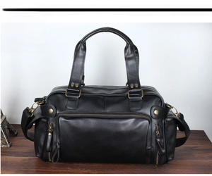 Front view of black PU leather large travel bag with multiple zippers and brass hardware