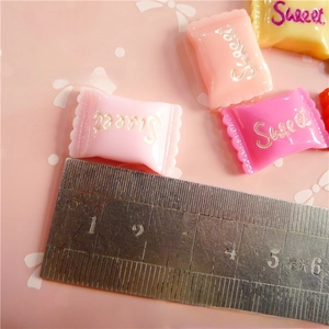 Macro shot of 25mm colorful resin candy charms with Sweet text for DIY crafts
