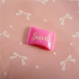 Close-up of pink resin candy charm with Sweet lettering for DIY crafts and hair accessories