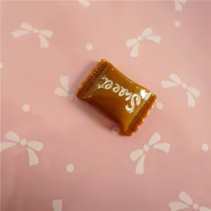 Close-up of coffee brown resin candy charm with Sweet text for DIY crafts and hair accessories