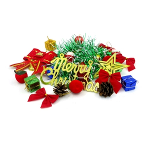 Detail view of mini Christmas tree decorations including gold bells, bows, and pine cones