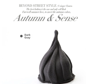 Detailed knit texture of a dark grey pointed beanie hat with vertical ribbed patterns