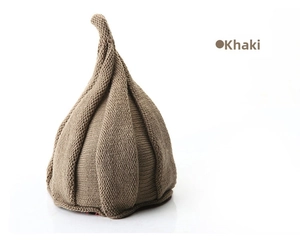 Close-up of khaki knitted windmill pointed hat with vertical ribbed texture on white background