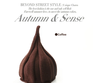 Detail of coffee brown knit beanie with vertical stripe texture and unique pointed top design