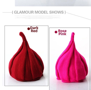 Detail view of dark red and rose red knitted baby hats with twisted pointed top design