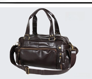 Detail of elegant brown PU leather travel bag with sturdy handles and metal hardware