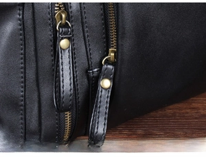 Detail view of black PU leather bag featuring vintage bronze zippers and leather pulls