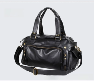 Detail view of black PU leather travel bag showing brass hardware and compartments