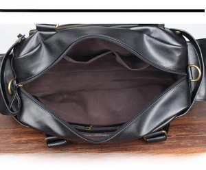 Interior detail of black PU leather travel bag with pockets for 14-inch laptop