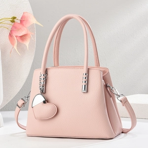 Detail der rosa Totebag aus Leder mit silbernen Beschlägen und Herz-Anhänger
