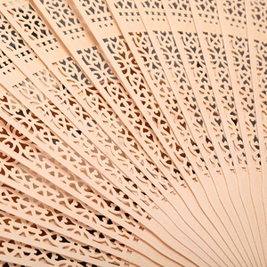 Close-up of 8-inch fragrant wooden folding fan featuring intricate hollowed-out carvings