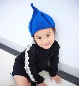 Toddler in blue pointed knit beanie featuring ribbed texture and elf style design