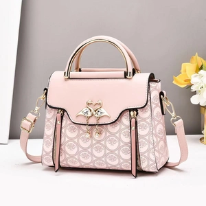 Pink woven patterned crossbody bag with metallic top handle and elegant swan buckle detail