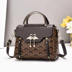 Brown patchwork crossbody bag with swan clasp and pearl tassel on a floral background