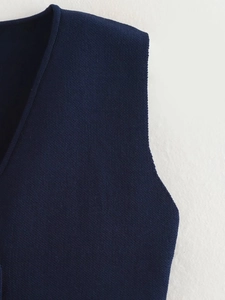 Close-up of navy blue knitted vest showing high-density fabric texture and stitching details