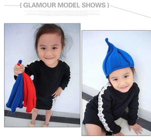 Detail of children's knitted pointed hats in blue and red featuring soft yarn textures