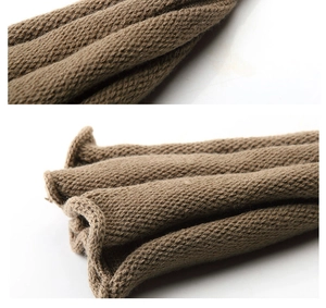 Close-up of brown knit fabric texture showing thick yarn weave and stitching details