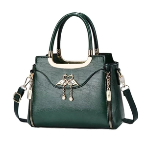 Deep green leather handbag with golden flamingo pendant and metal top handle