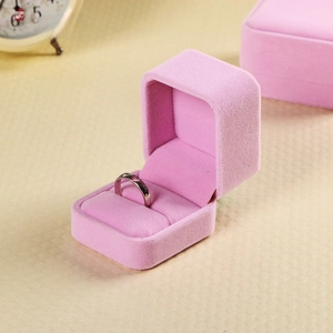 Detailed view of a pink velvet ring box featuring a soft interior for jewelry display
