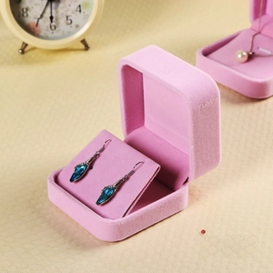 Detailed view of a pink velvet jewelry box with internal display for blue gemstone earrings