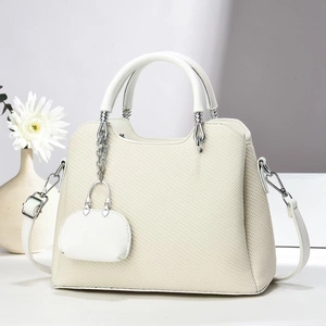 Creamy white woven texture handbag with top handle and detachable strap in a clean studio setting